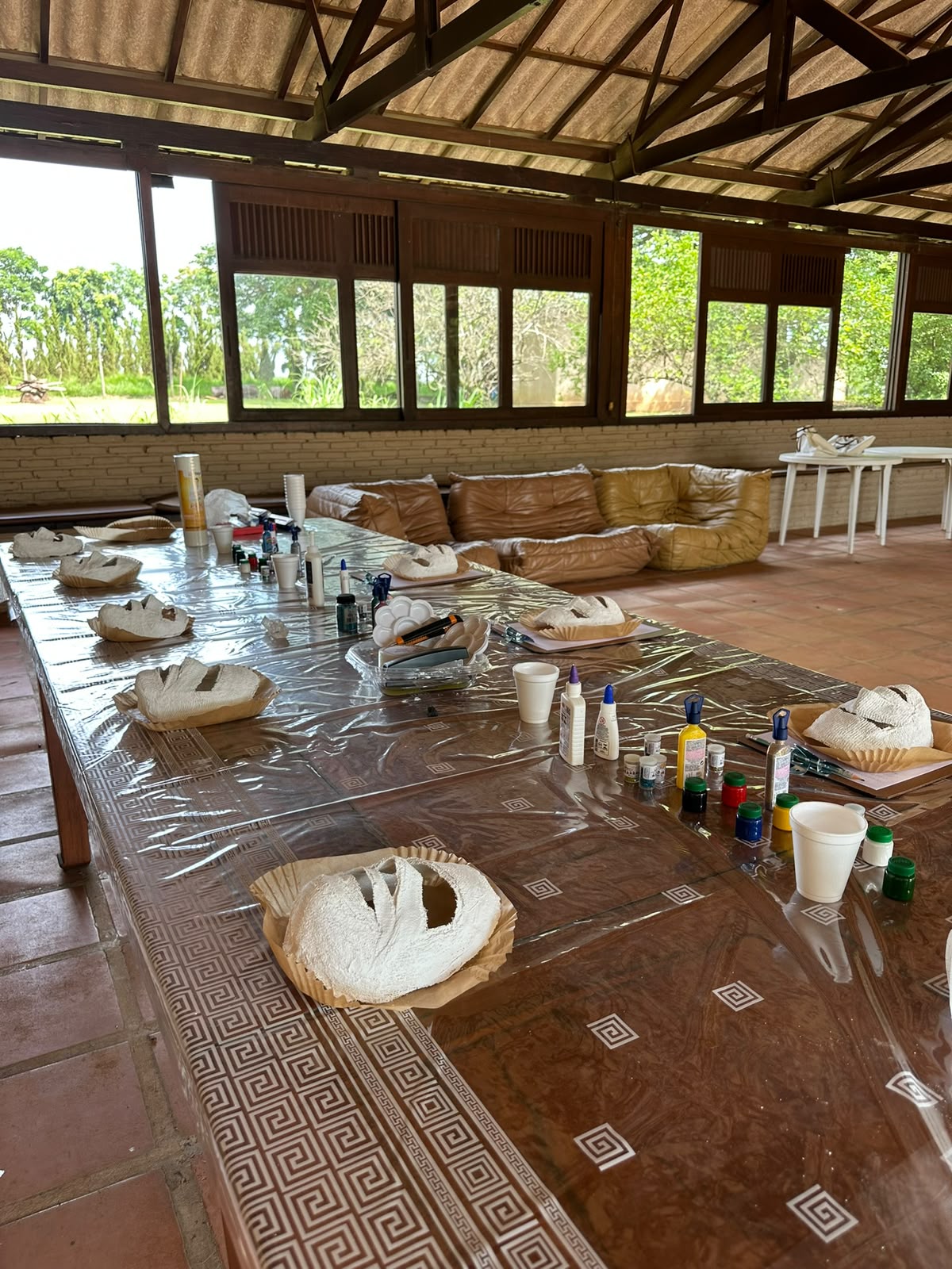Máscaras de gesso ainda brancas secando sobre a mesa do salão